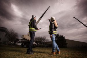 An instructor and a woman bieng instructed on being a crane operator